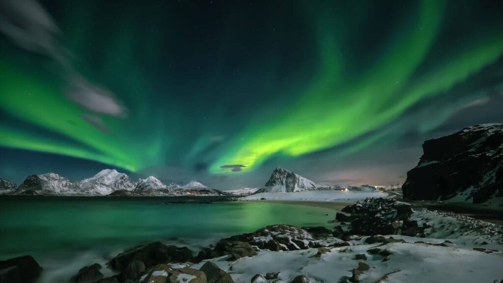 Green Aurora Borealis over the lake.